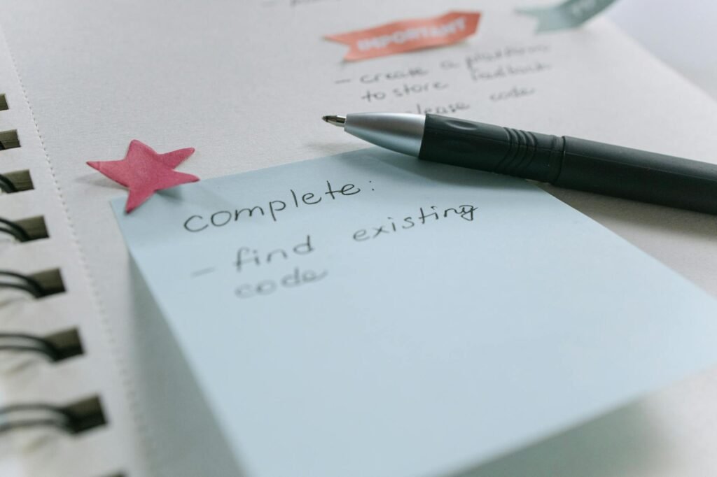 A handwritten checklist next to a notebook with budget notes and receipts.