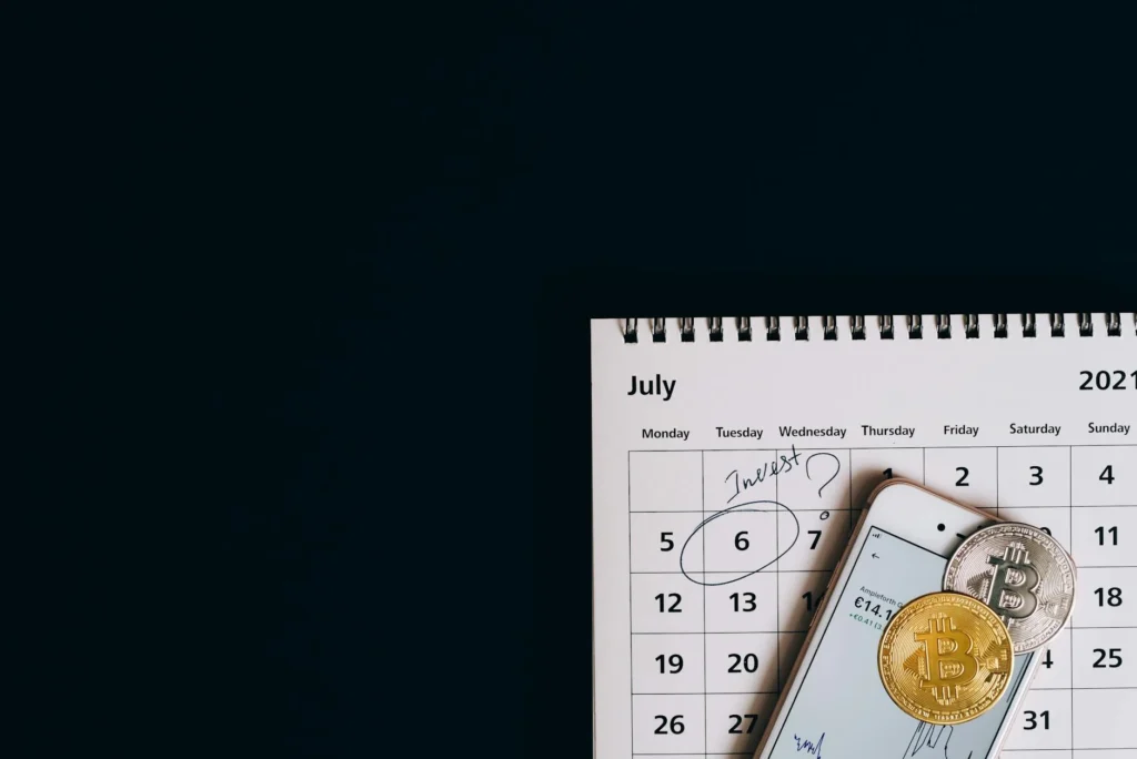 Keys, charger, wallet, and a notebook laid out neatly beside a calendar